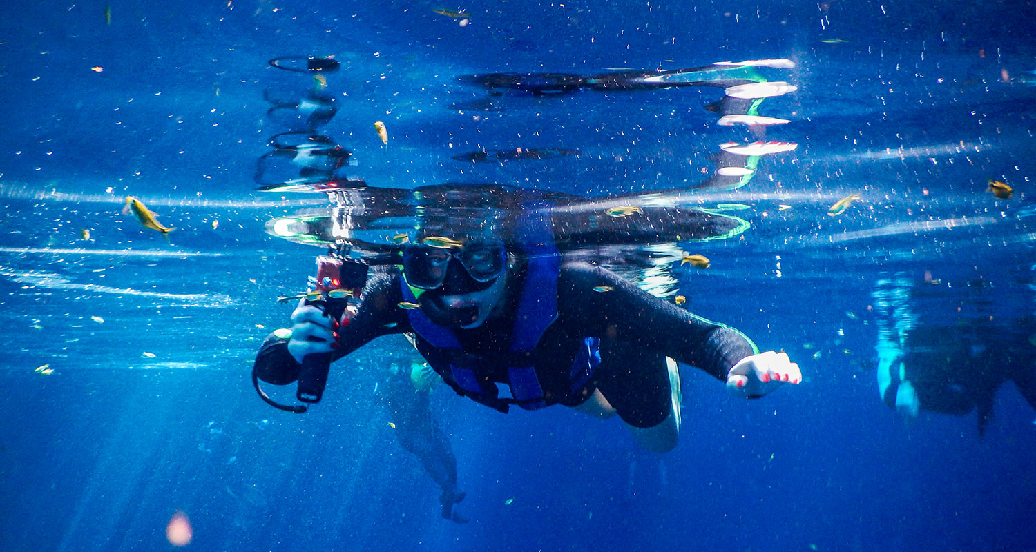 Homem mergulhando no mar azul. 