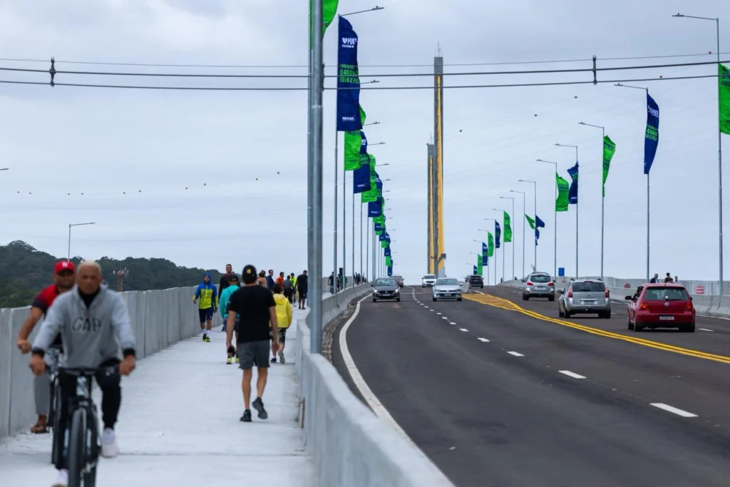 Veículos, ciclistas e pedestres na Ponte de Guaratuba durante inauguração no Paraná.