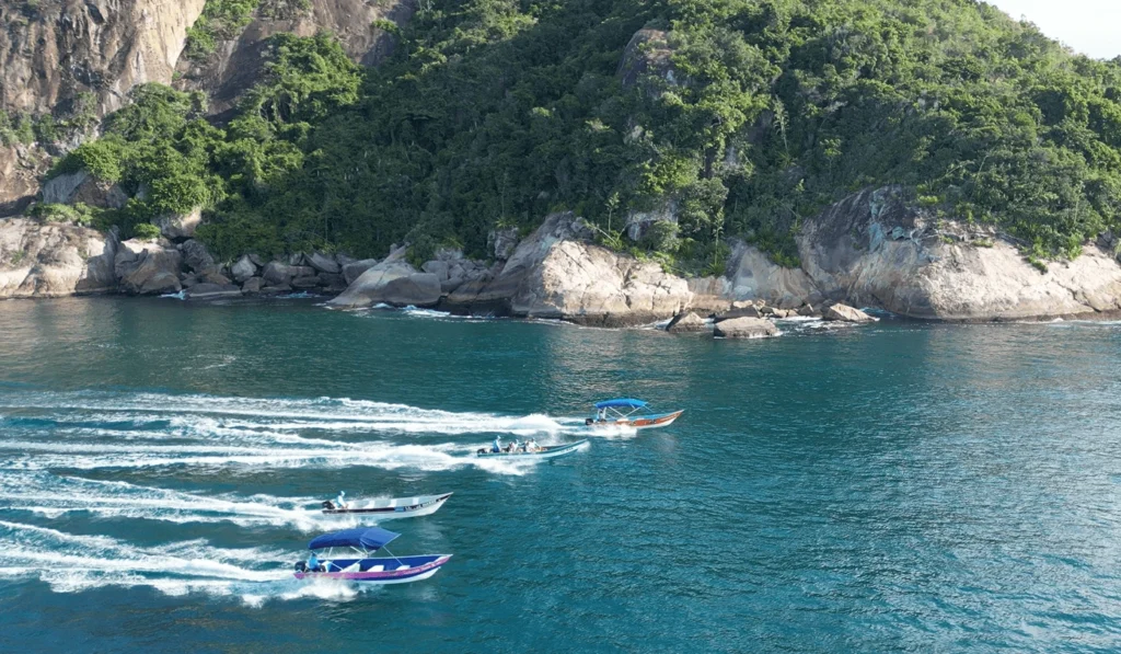 Embarcações navegam próximas aos paredões rochosos da Ponta da Juatinga, em Paraty