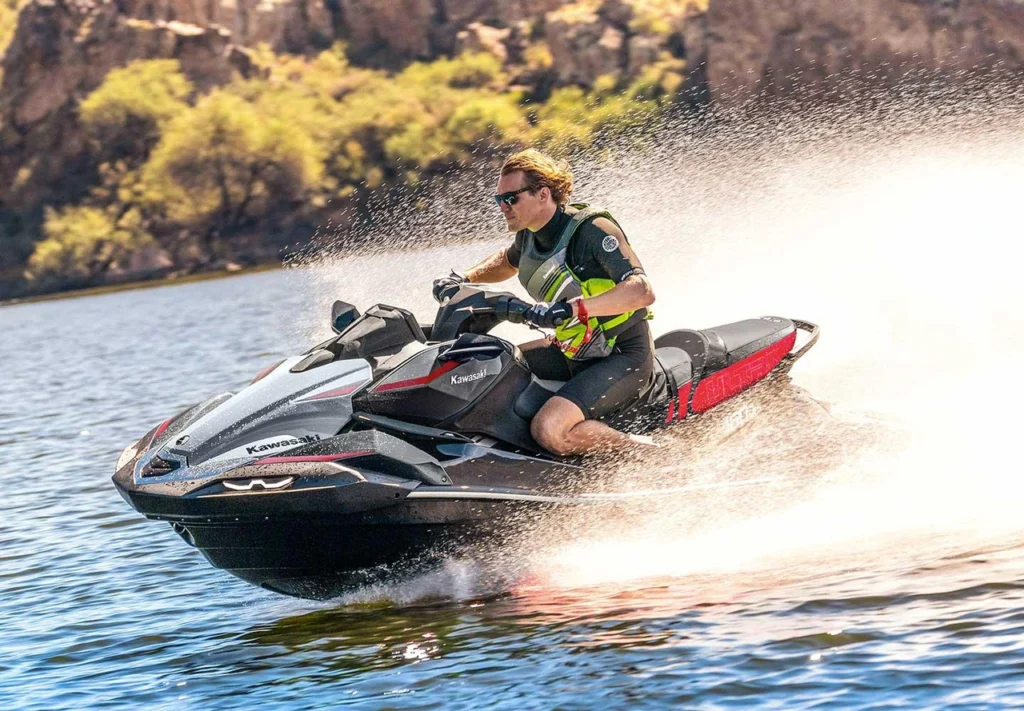 Homem pilotando jet ski Kawasaki em alta velocidade no lago