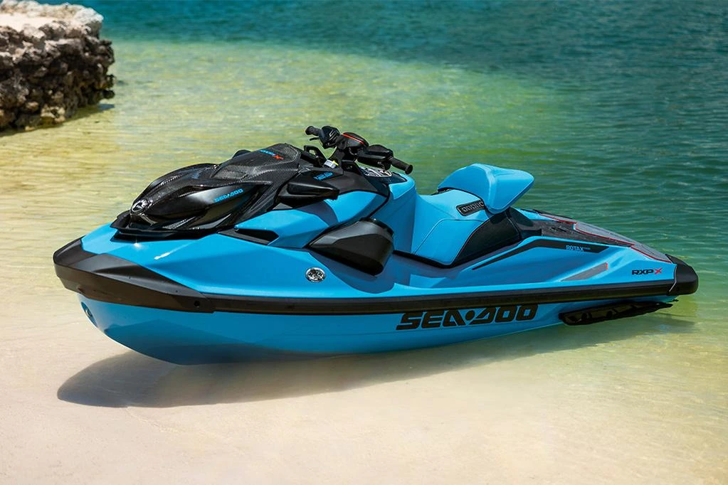 Jet ski Sea-Doo azul estacionado na areia próximo ao mar
