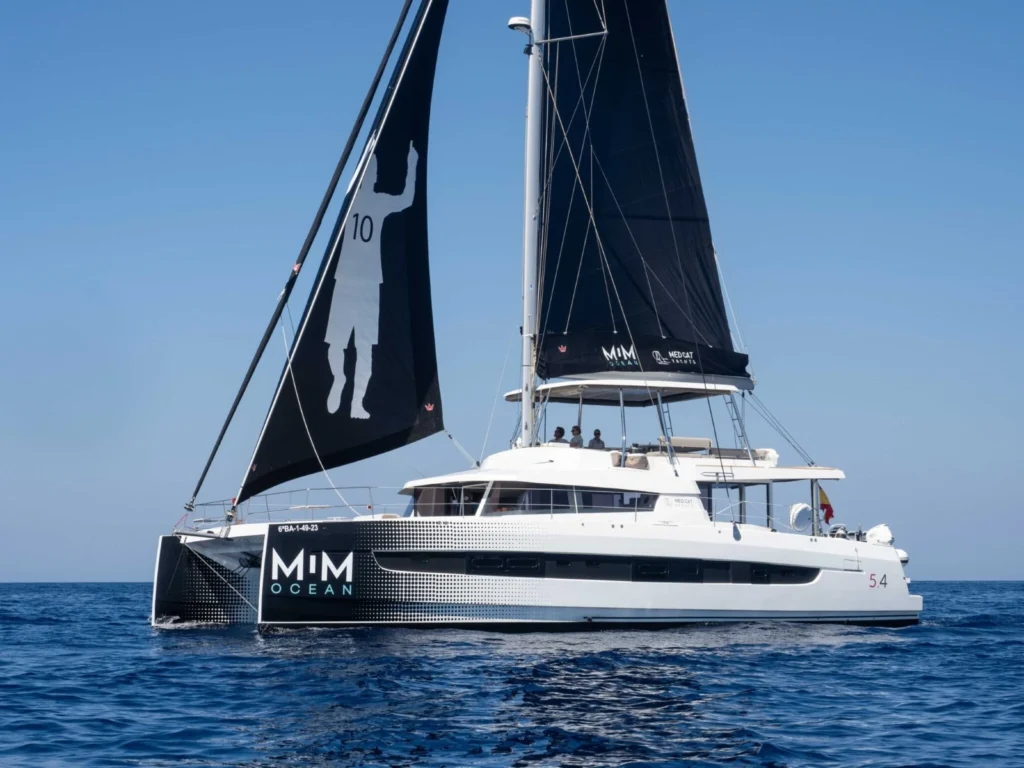 Catamarã Bali 5.4 com velas pretas personalizadas com a silhueta de Lionel Messi.