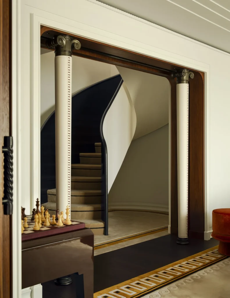 Área interna do Orient Express Corinthian com detalhes inspirados no estilo Art Déco e escadaria elegante.