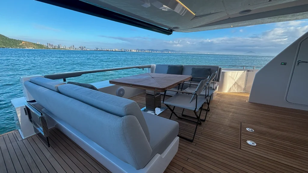 Área de convivência externa da Ferretti Yachts 850R com mesa, sofás e vista para o mar.
