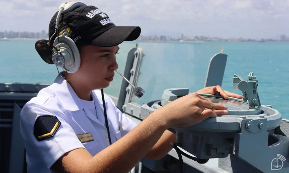 Militar da Marinha do Brasil opera equipamento de navegação em embarcação.