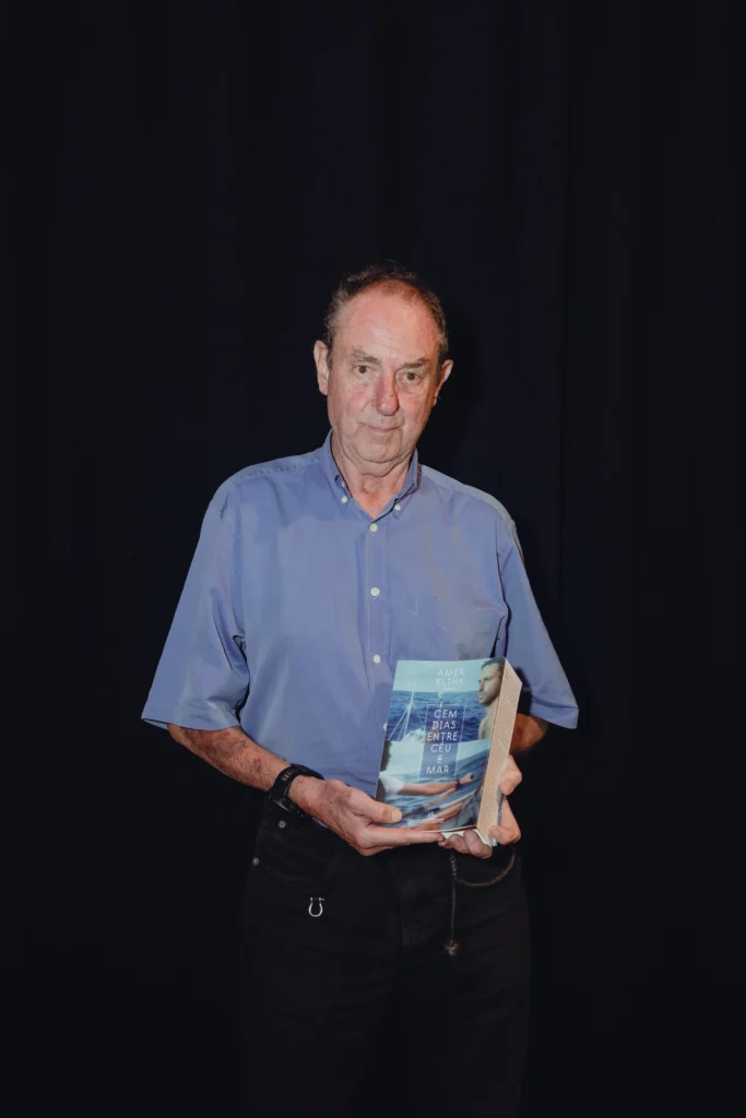 Amyr Klink segura um exemplar do livro Cem Dias Entre Céu e Mar, de Amyr Klink.